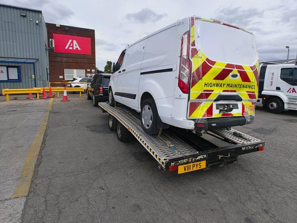 White van loaded onto a recovery trailer